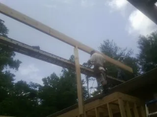 Carpenter setting a ridge beam over a new addition frame — Ice Dam Removal by Roofing Brothers in Jacobsburg
