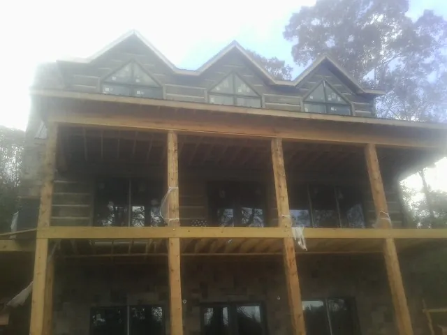 Dormers and porch framing on a large log home under construction — Roof Coating work by our crew in Jacobsburg