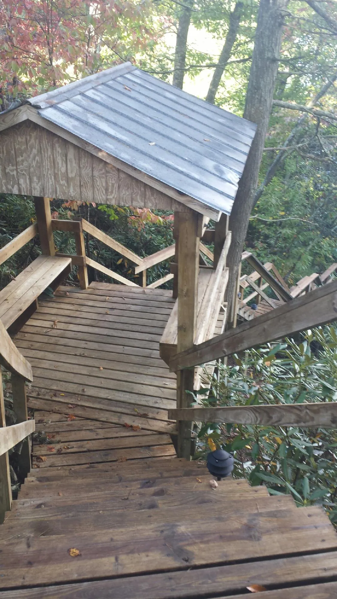 Metal roofed shelter over wooden steps on a wooded walkway — Skylight Repair & Installation work by our crew in Jacobsburg