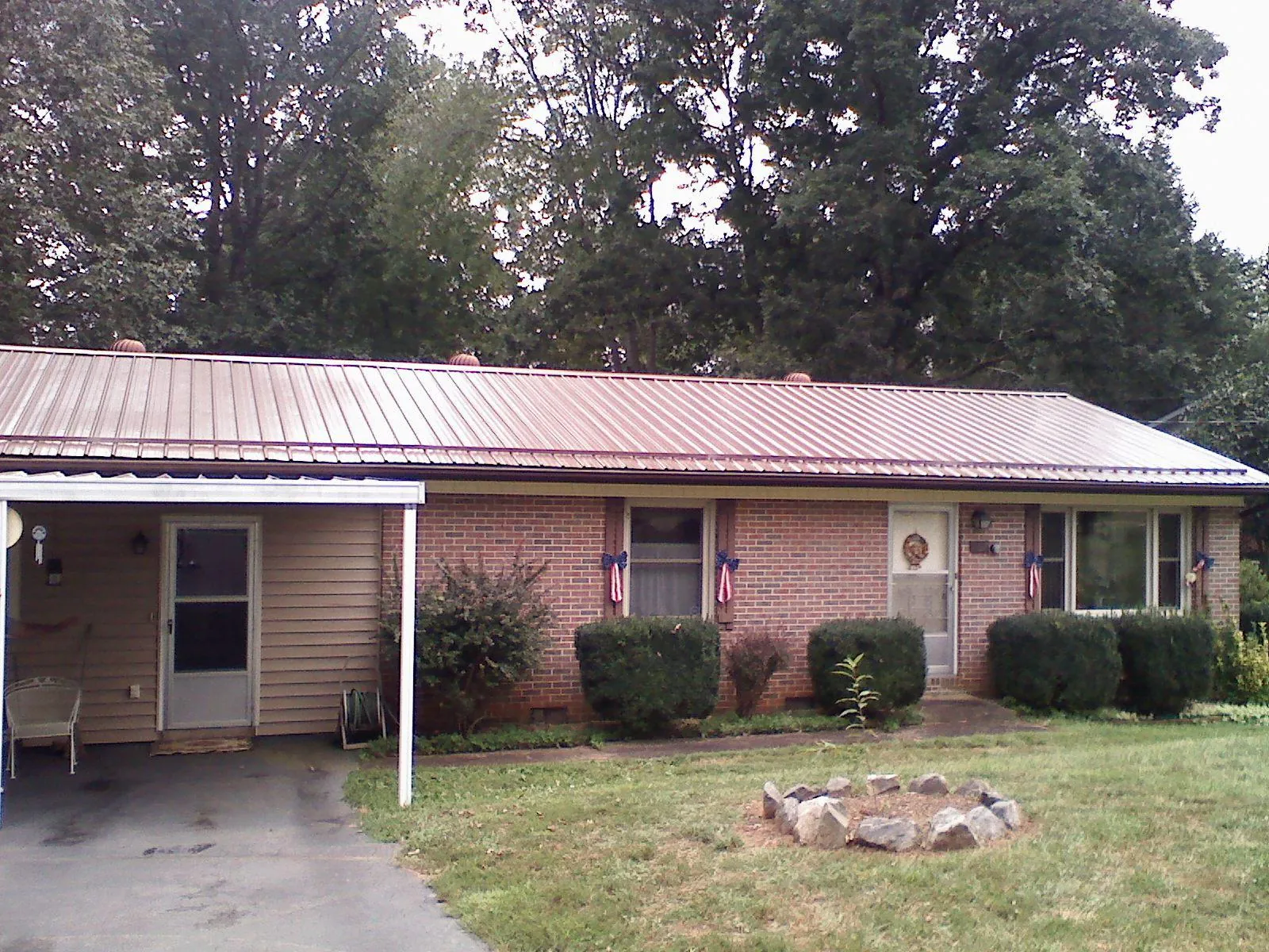 Bronze metal roof and carport on a brick ranch home — Roof Repair work by our crew in Jacobsburg
